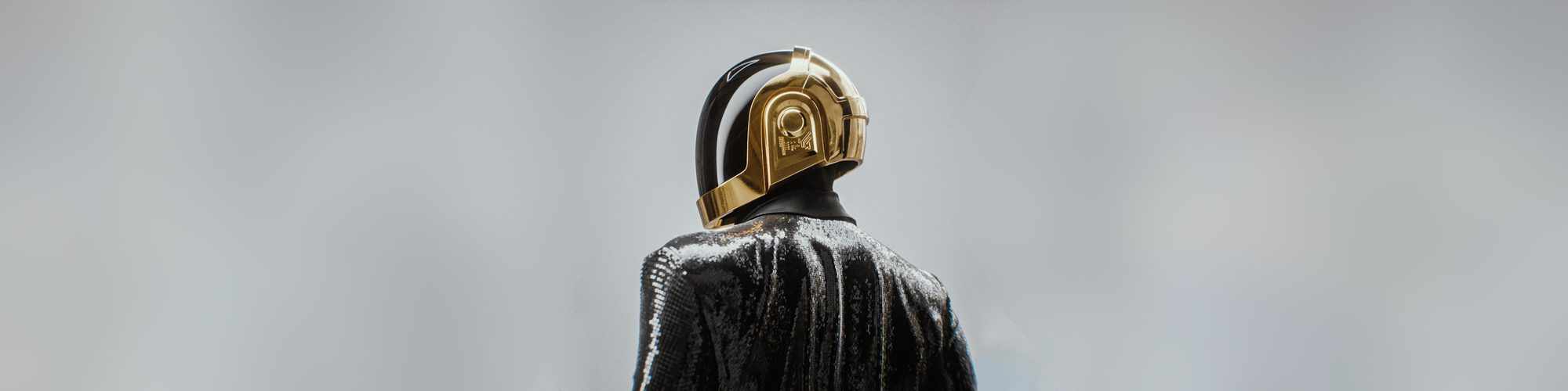 Daft Punk gold helmet seen from behind over a sequinned jacket